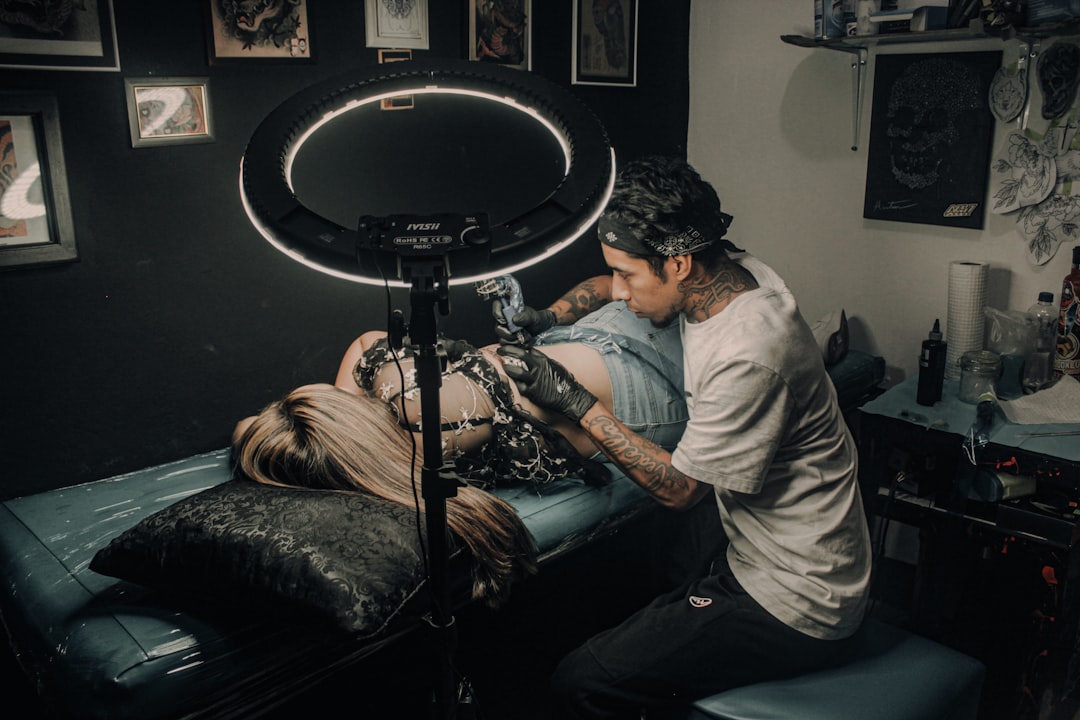 Photo by Tony Rocket a man with a tattoo on his arm and a woman with a drum